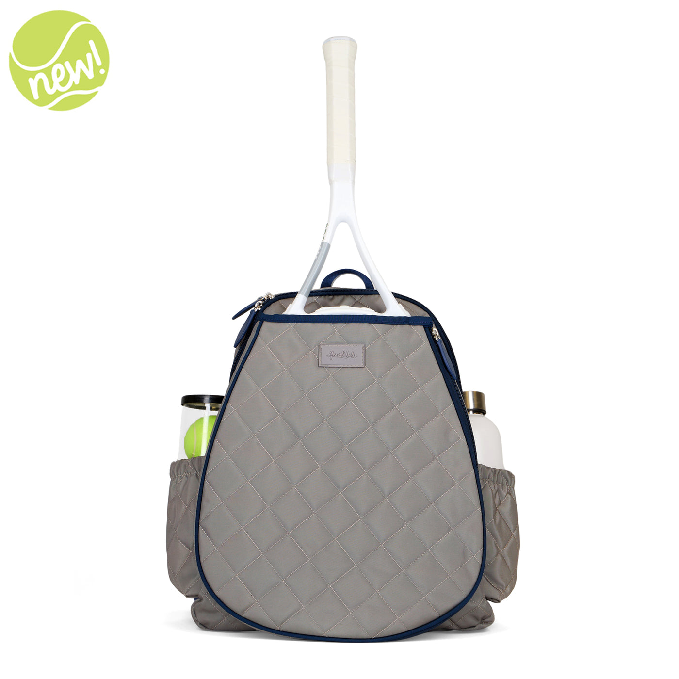 Women's tennis backpack with quilted grey nylon fabric and navy trim. The front pocket is holding a tennis racquet.