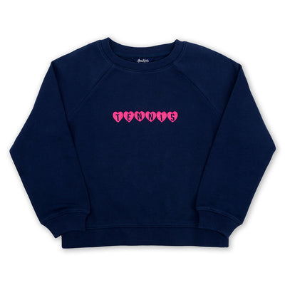 Navy kids sweatshirt lays flat on a white background. Pink hearts with the word tennis over them is embroidered on the front of the sweatshirt