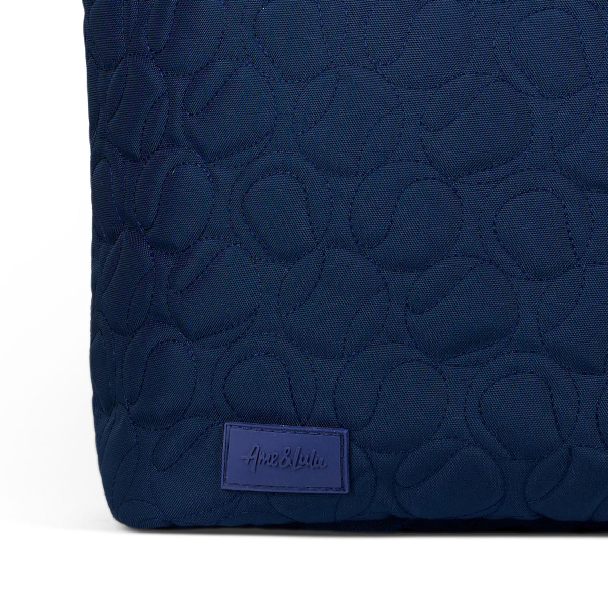 Navy nylon tennis tote with tennis ball quilted pattern.