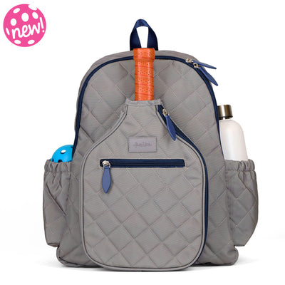 Quilted grey nylon with navy trim pickleball backpack with paddle shaped pocket on the front with paddle inside.